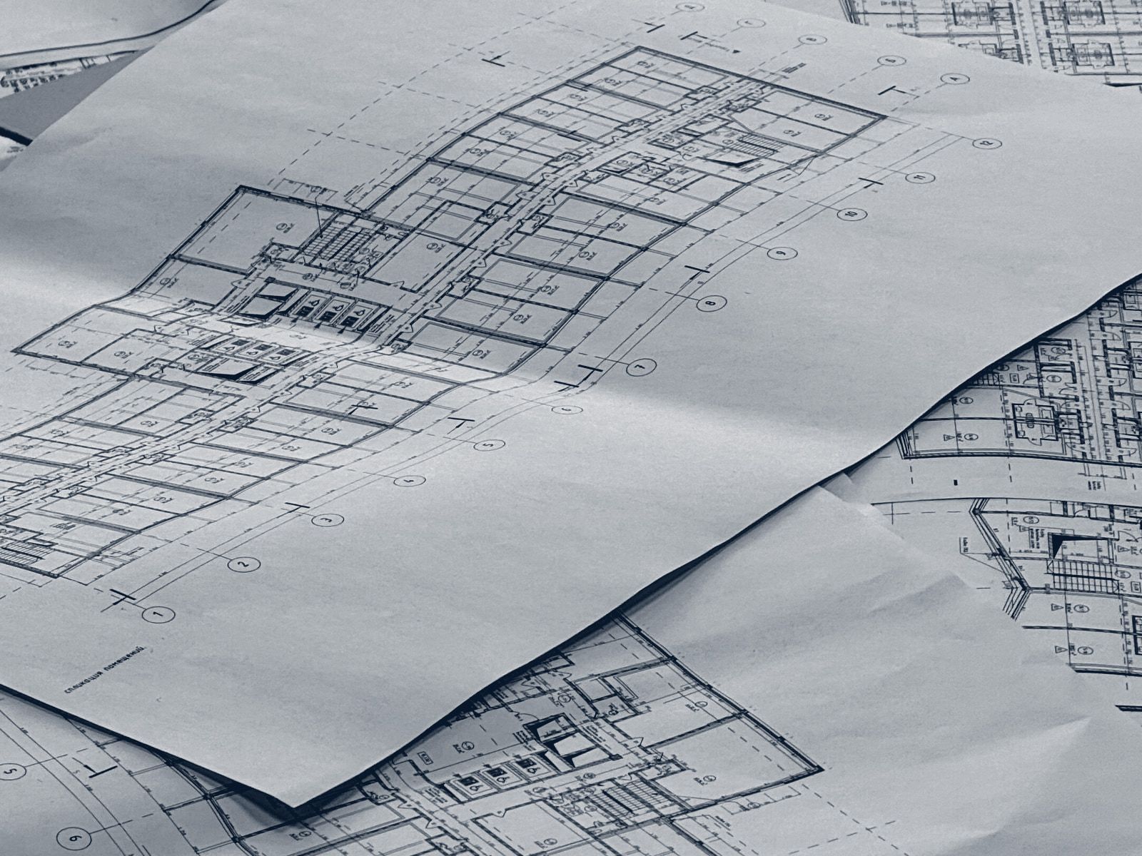 Printed floor plans lying across one another on a table.